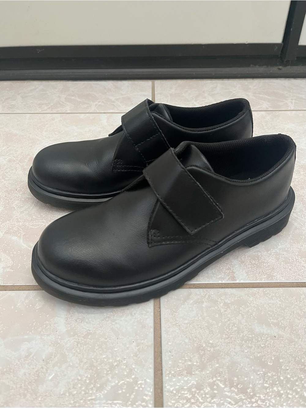Black leather loafers with velcro strap closure